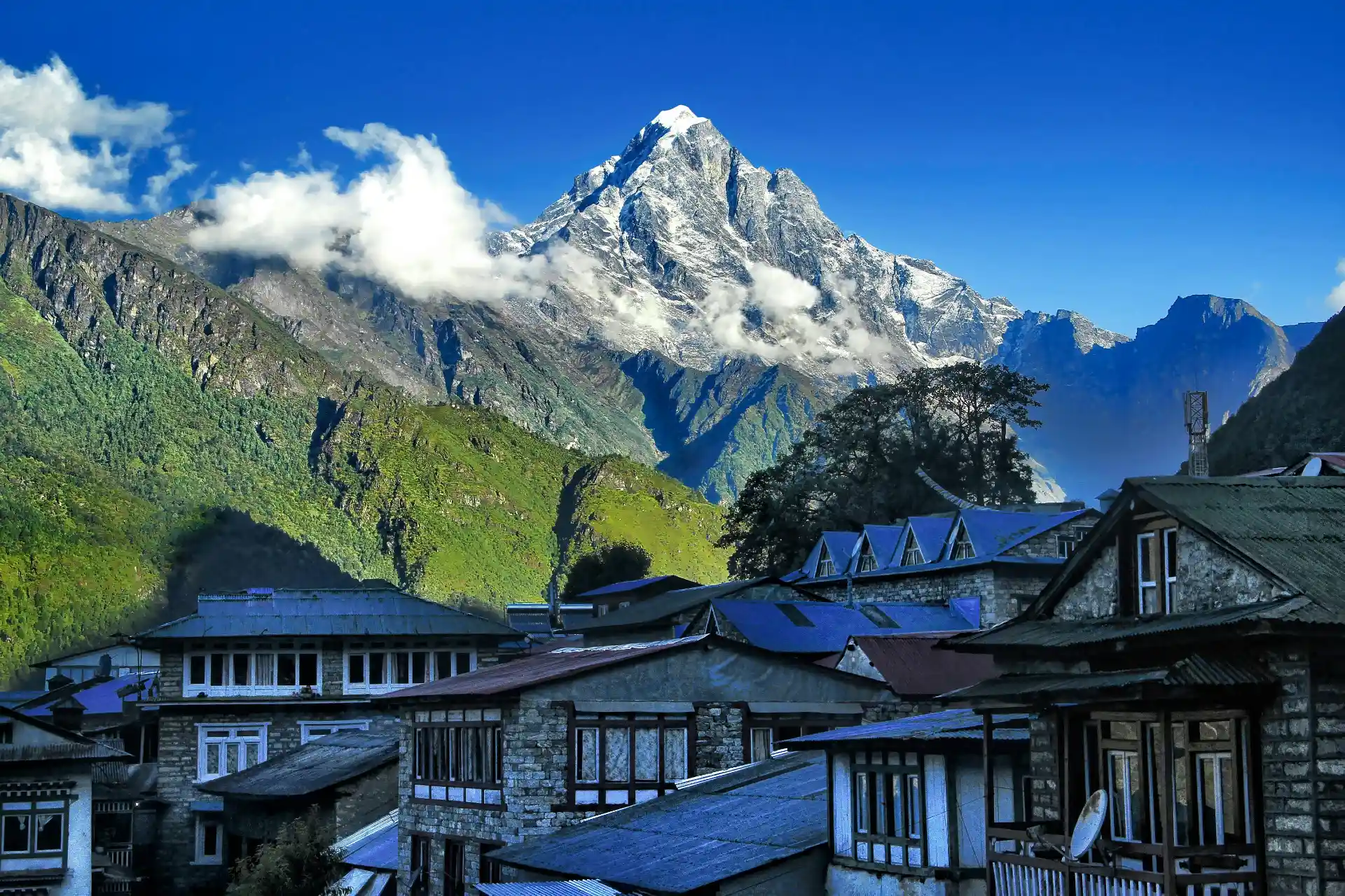 Breathtaking view of the Himalayas with traditional Nepalese houses in the foreground.