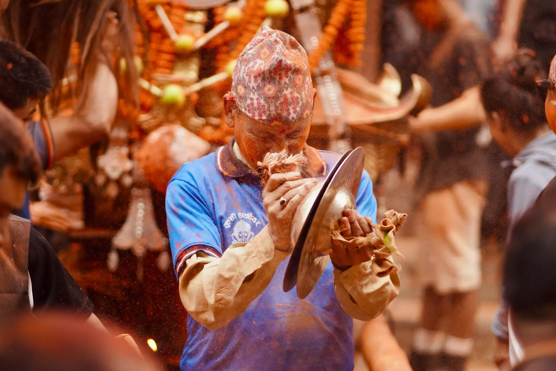 A lively Nepali New Year festival scene with a man playing a musical instrument amidst colorful festivities.
