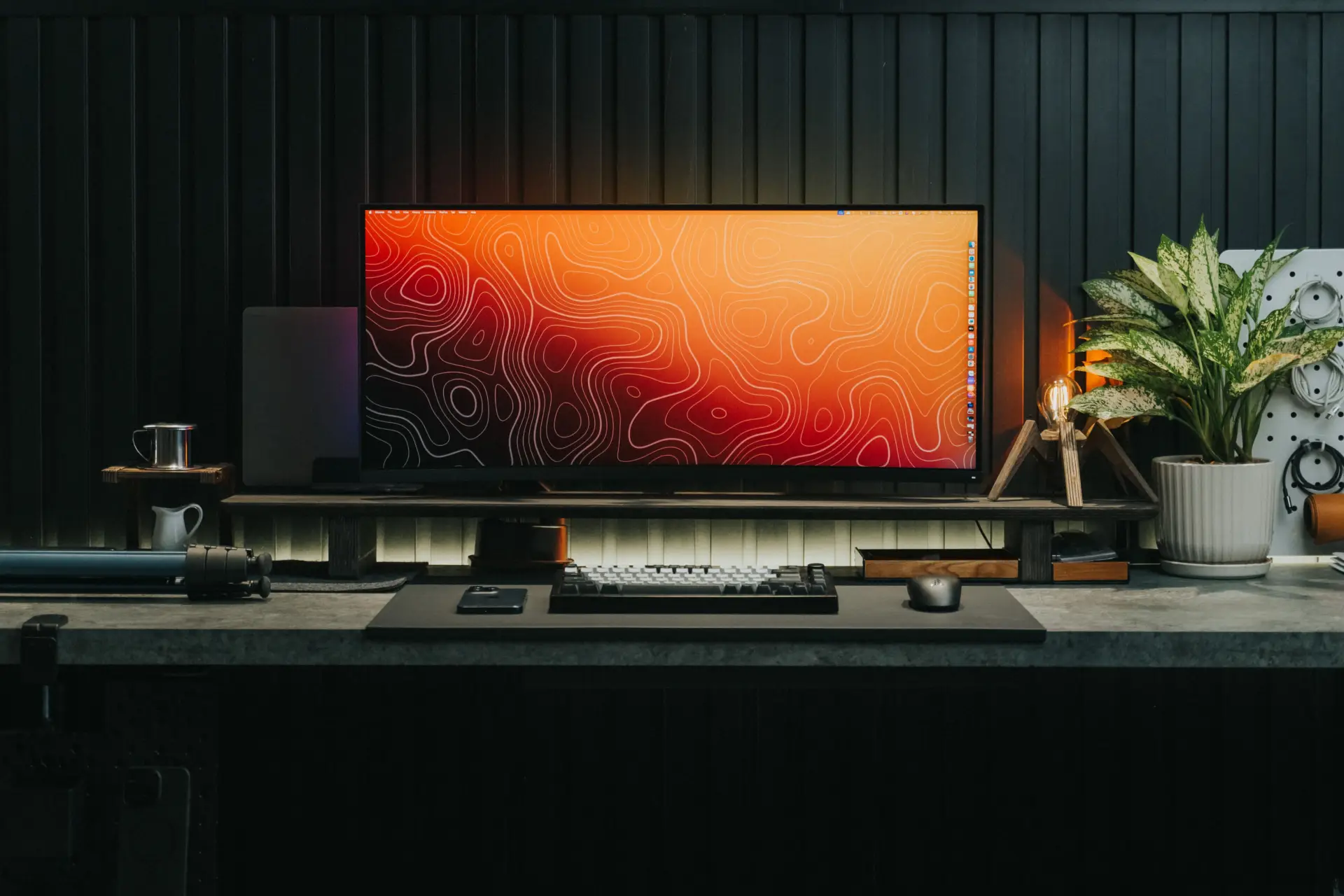 A sleek gaming desk setup featuring a modern monitor, keyboard, and decorative elements, ideal for gamers or professionals.
