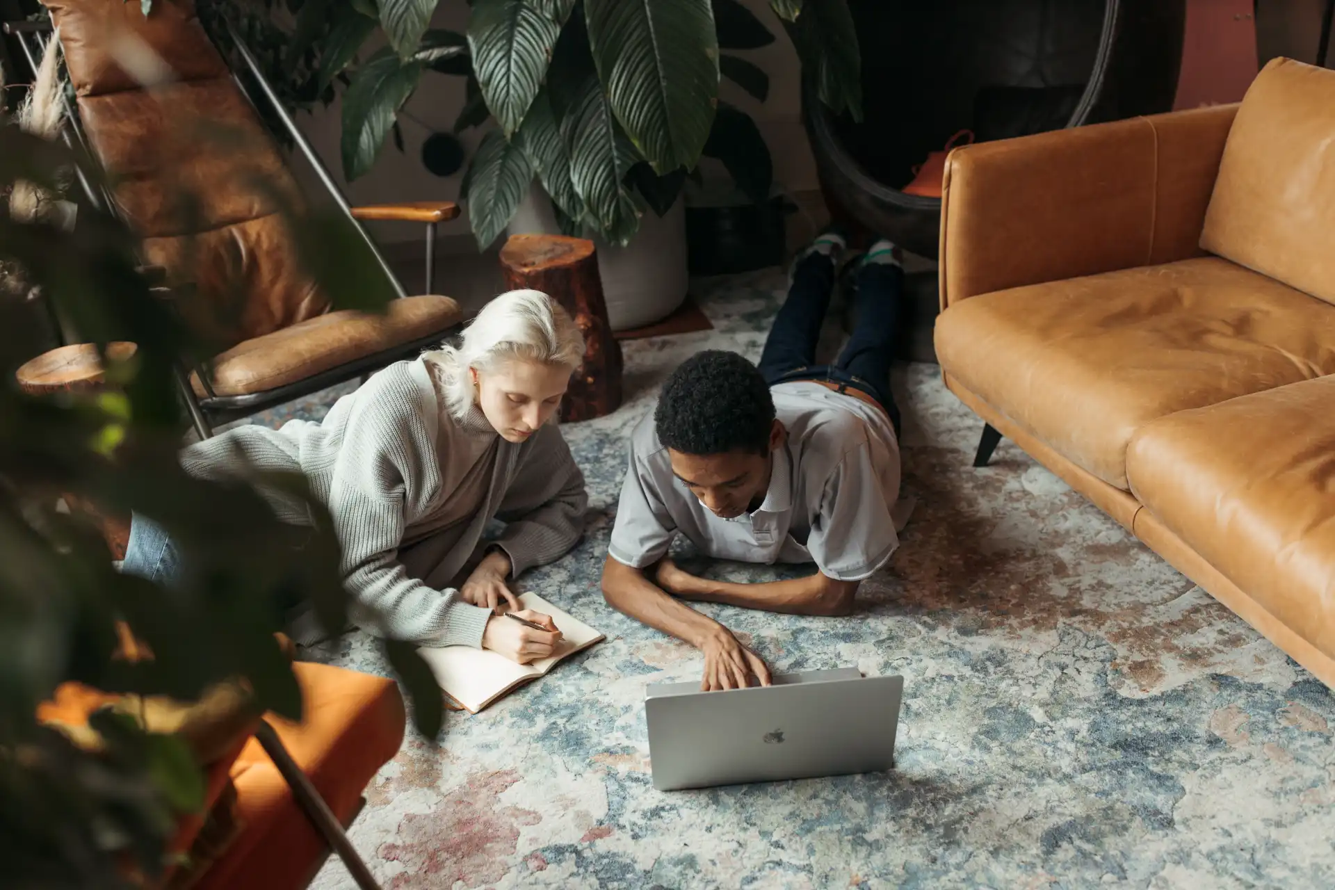 Creative coworkers collaborating in a cozy, modern indoor office setting with a laptop.
